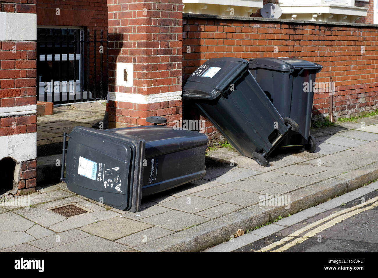 wheelie bins left strewn across pavement after being emptied england uk