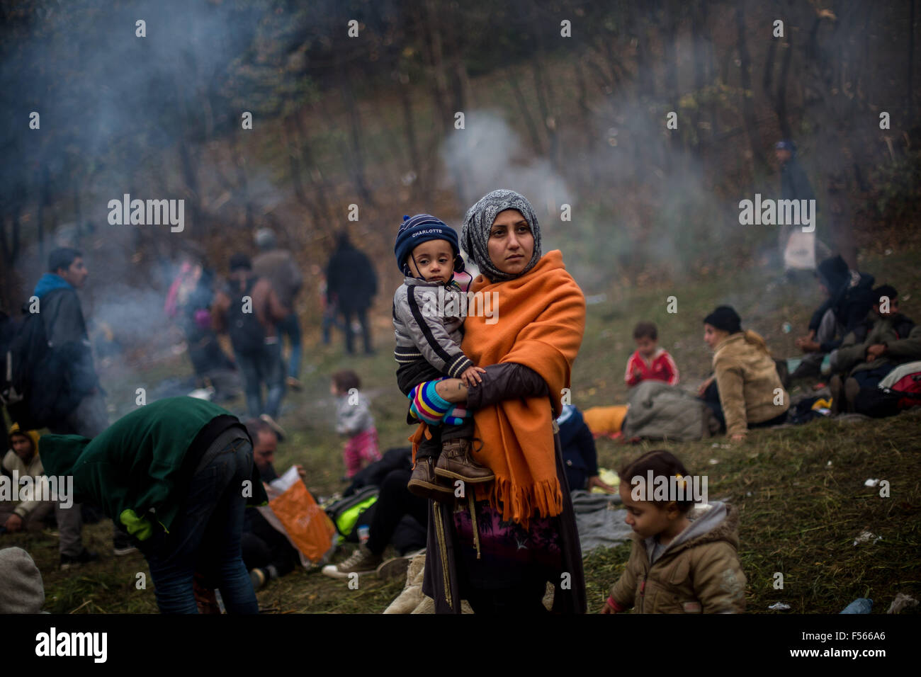 Sentilj, Slovenia. 28th Oct, 2015. A woman and child refugee from Syria wait at the border to Austria in Sentilj, Slovenia, 28 October 2015. The asylum seekers were brought to emergency accomodation by bus. Photo: MAJA HITIJ/DPA/Alamy Live News Stock Photo