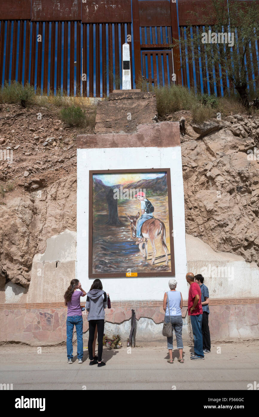 Nogales, Sonora Mexico - Tourists view a painting below the border fence separating the United States and Mexico. Stock Photo