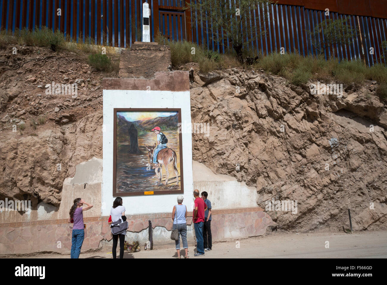 Nogales, Sonora Mexico - Tourists view a painting below the border fence separating the United States and Mexico. Stock Photo