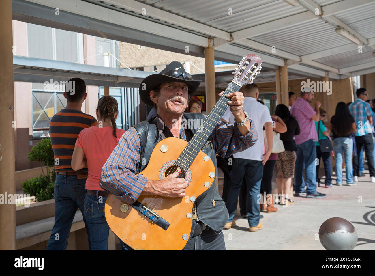 Nogales, Sonora Mexico - A man sings for pedestrians waiting to cross from Mexico to the United States. Stock Photo