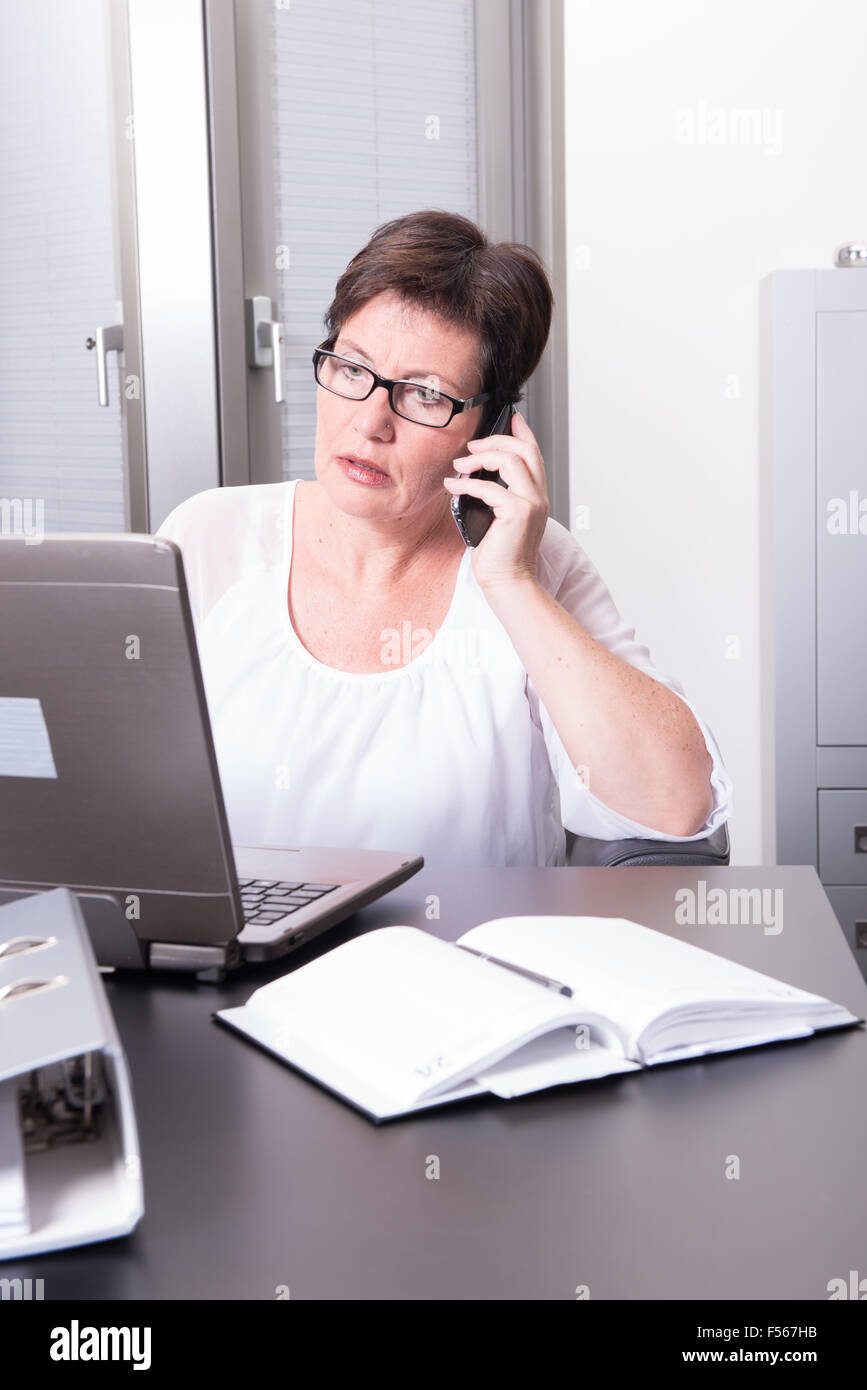 woman in her homeoffice on the phone Stock Photo