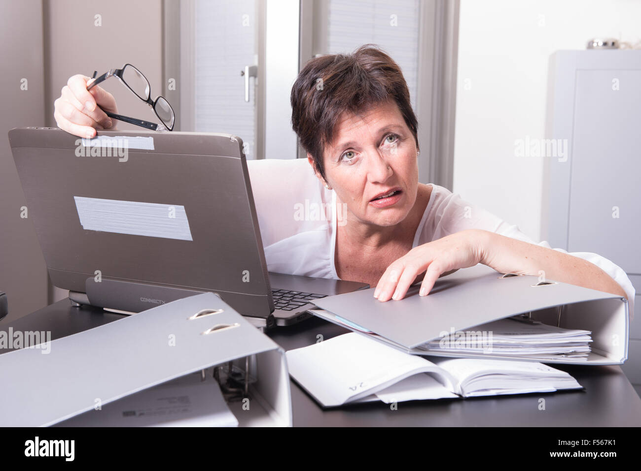 woman in her homeoffice is completely overworked Stock Photo