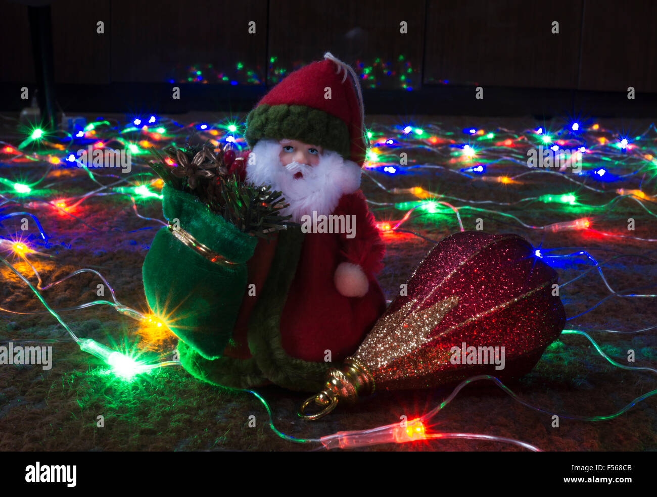 Grandparent Frost with toy on festoon of the colour lights on dark background Stock Photo