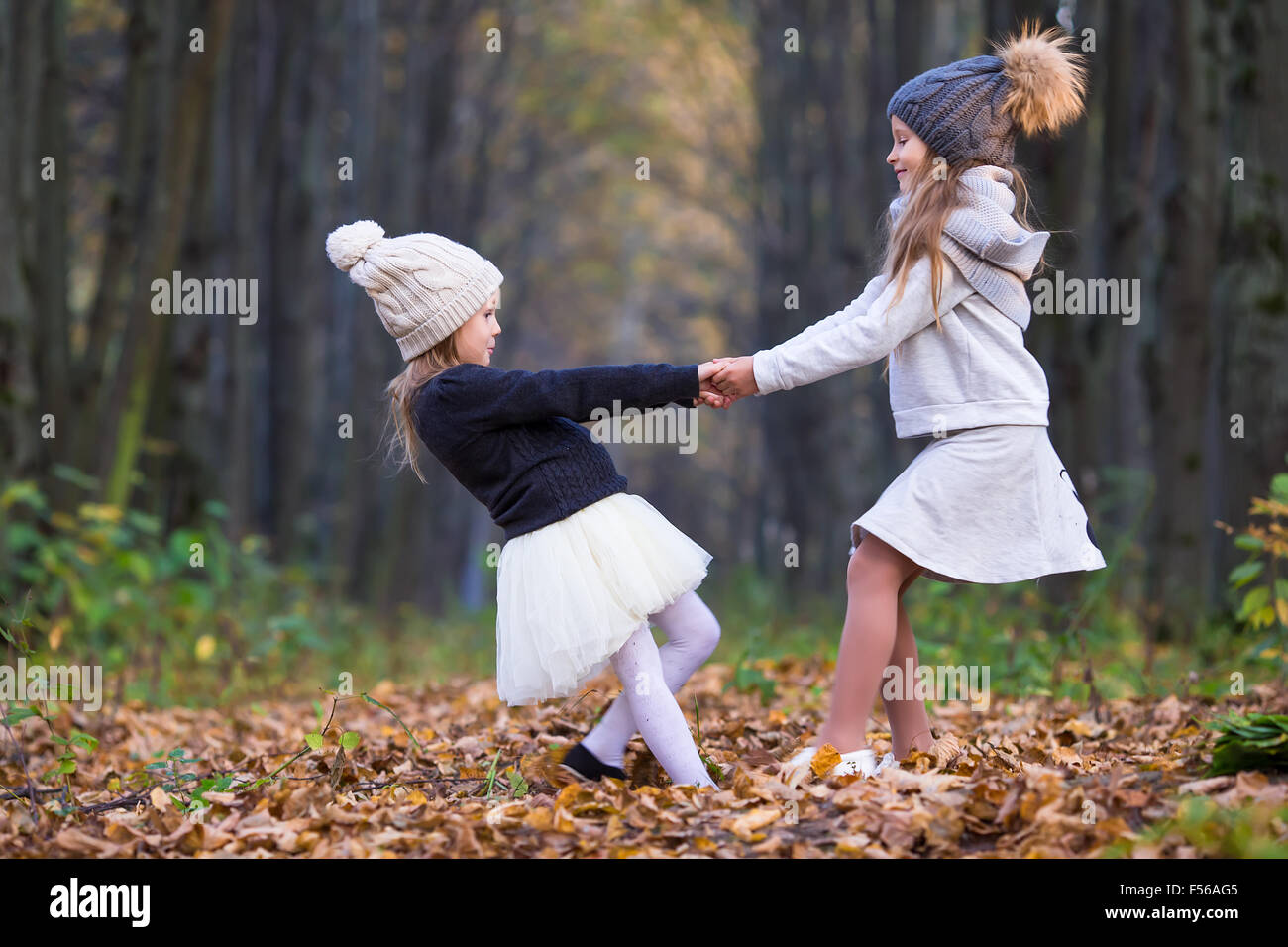 Little adorable girls outdoors at warm sunny autumn day Stock Photo - Alamy