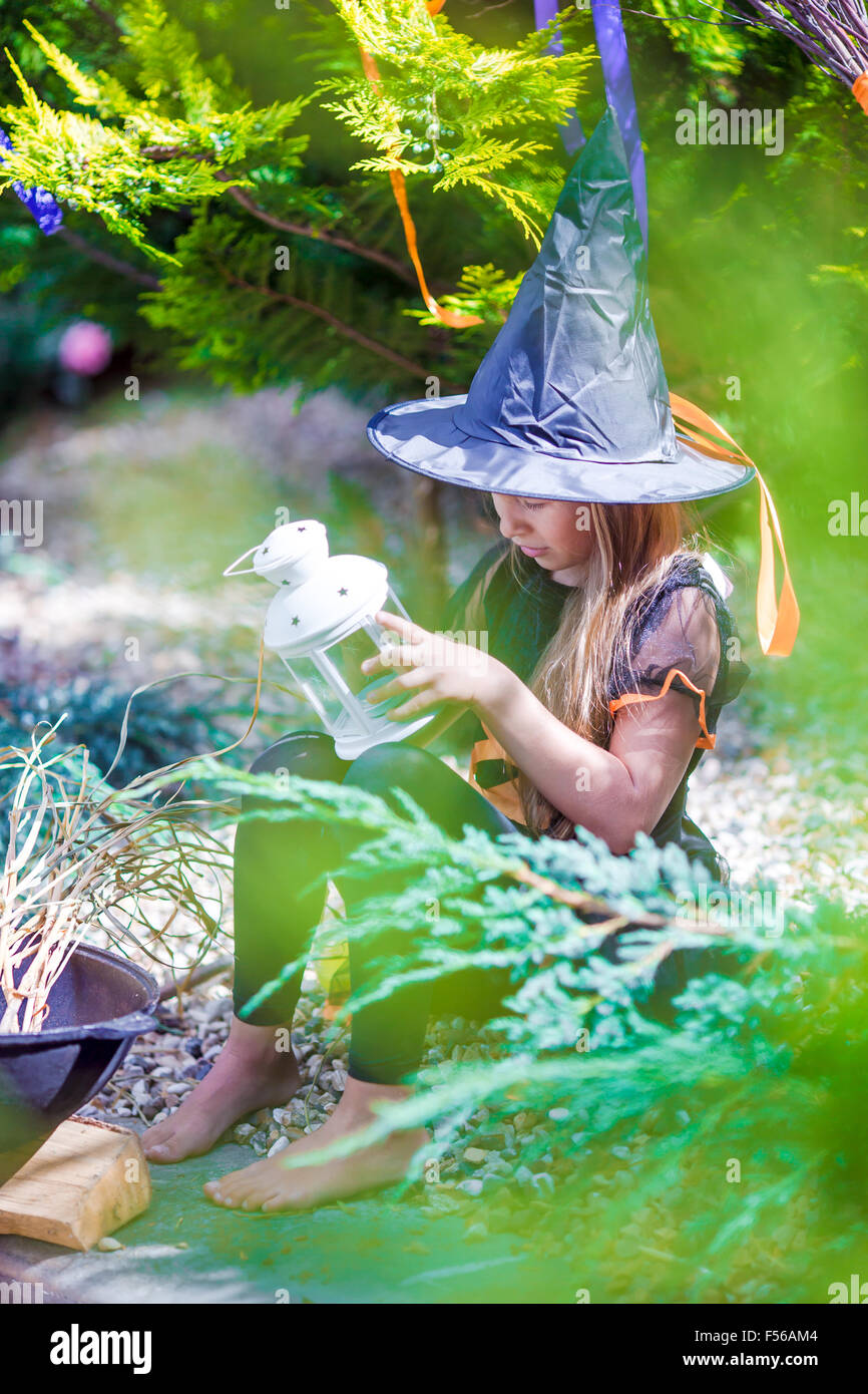 Adorable little girl in witch costume casting a spell on Halloween ...