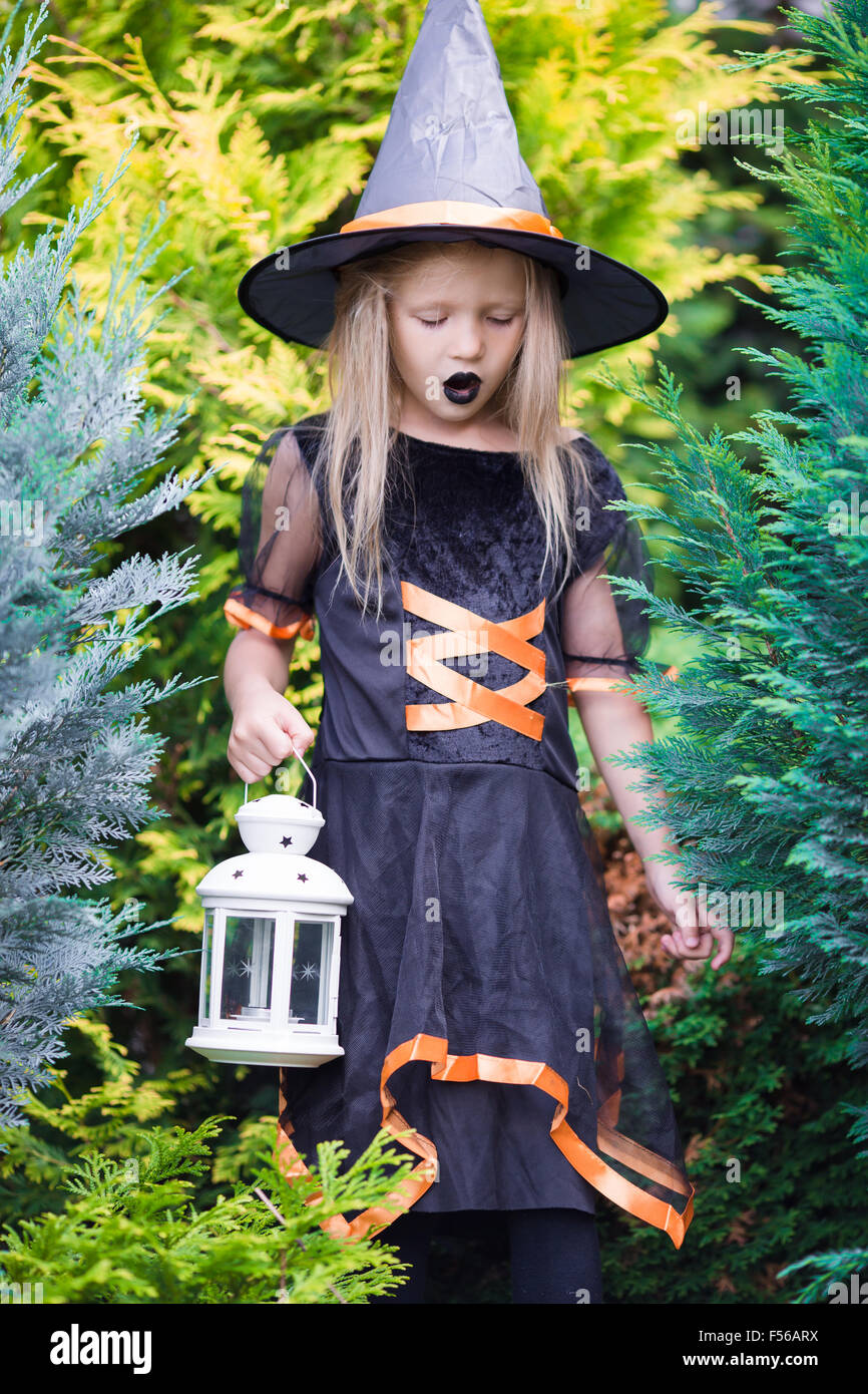 Adorable amasing little girl wearing witch costume on Halloween. Trick ...