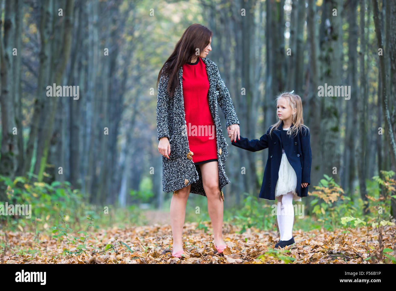 Adorable little girl with mother in autumn park outdoors Stock Photo ...