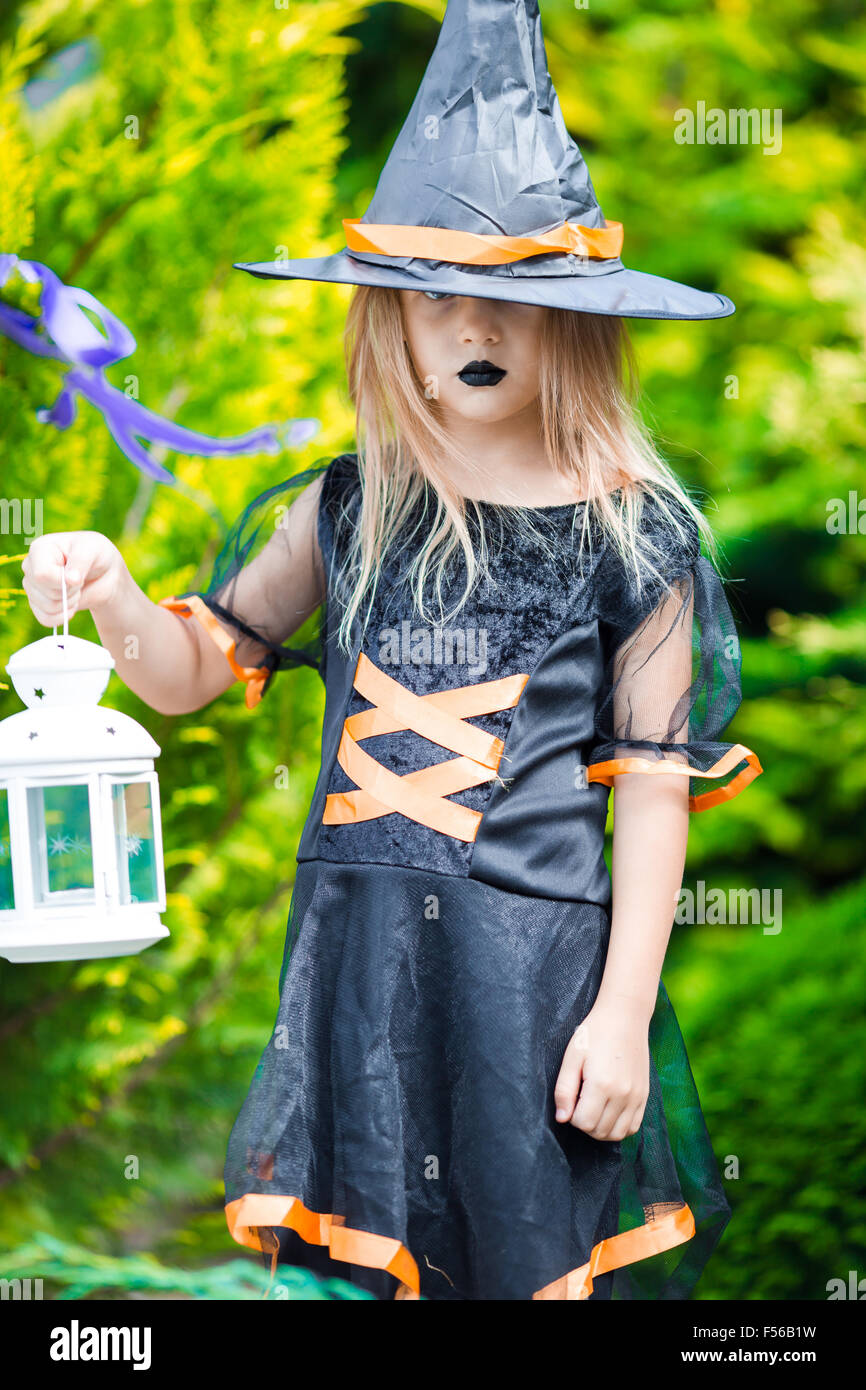 Adorable little girl wearing witch costume on Halloween at autumn day ...