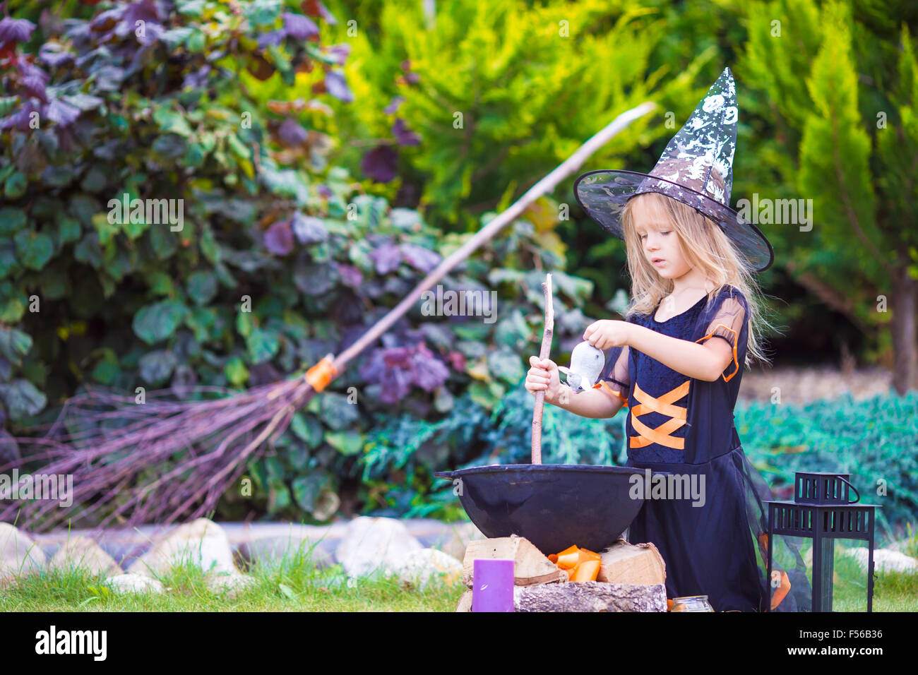 Adorable little girl wearing witch costume on Halloween at autumn day ...