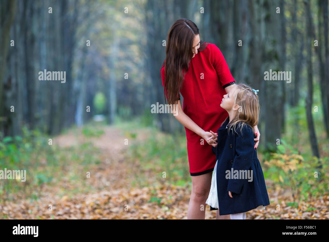 Adorable little girl with mother in autumn park outdoors Stock Photo ...