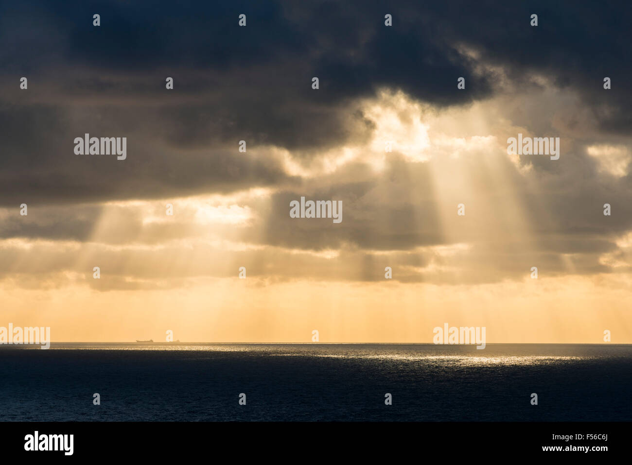 West Bay, Dorset, UK.  28th October 2015.  UK Weather - Beams of light shining through the clouds and onto the sea off the coast  of West Bay, Dorset, UK shortly before sunset.  Picture Credit: Graham Hunt/Alamy Live News Stock Photo