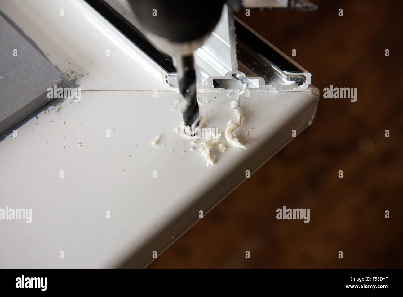 Drilling hole into plastic soffit board Stock Photo Alamy