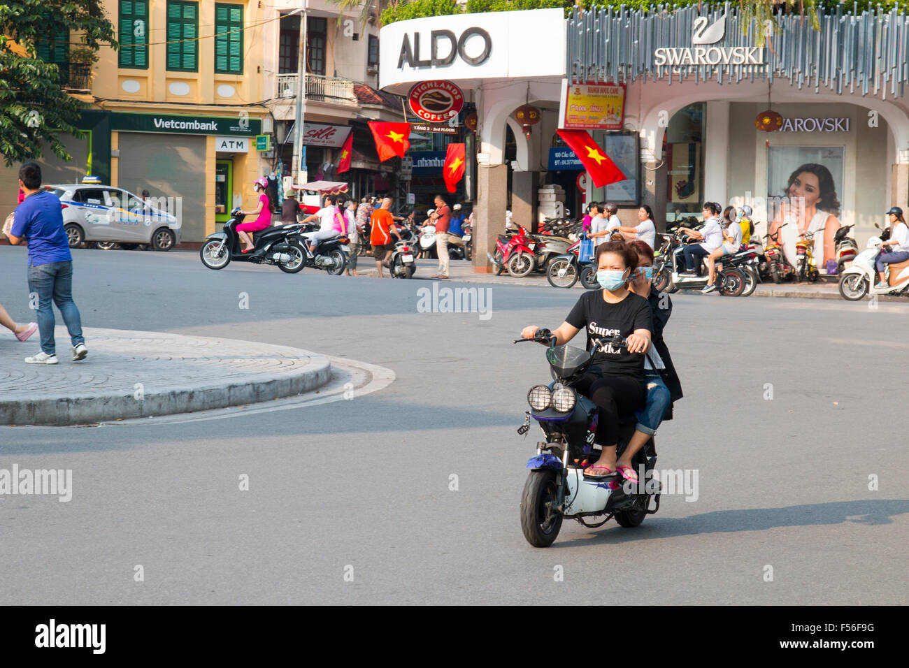 Hanoi,Vietnam, two vietnamese women on an electric bike motorcycle in Hanoi old quarter northern end of hoan kiem lake,Hanoi. Stock Photo