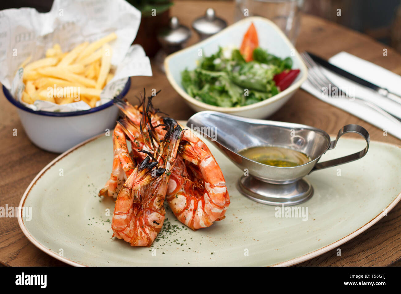 Grilled Madagascar Tiger Prawns with a bowl of salad and chips Stock