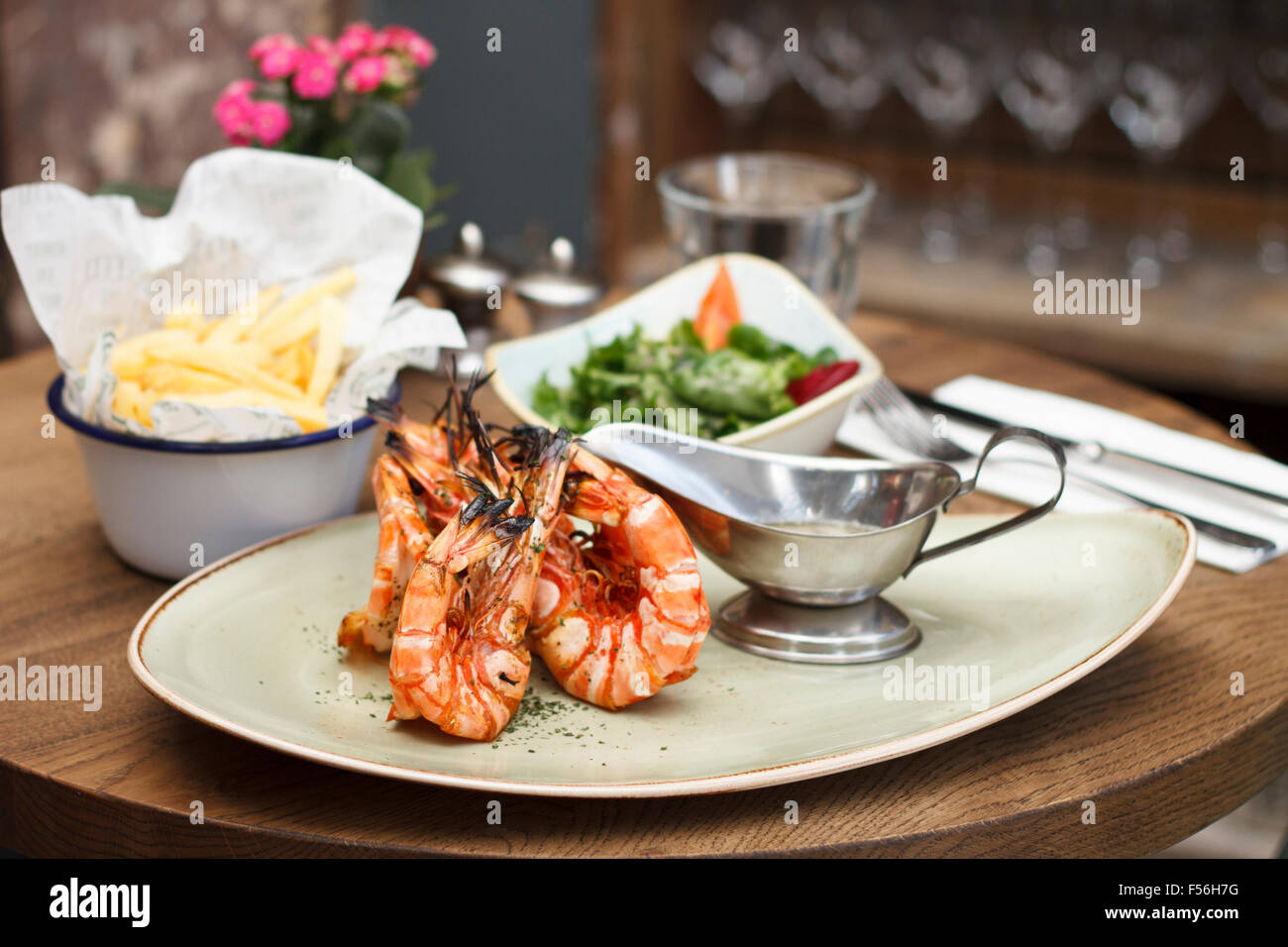 Grilled Madagascar Tiger Prawns with a bowl of salad and chips Stock