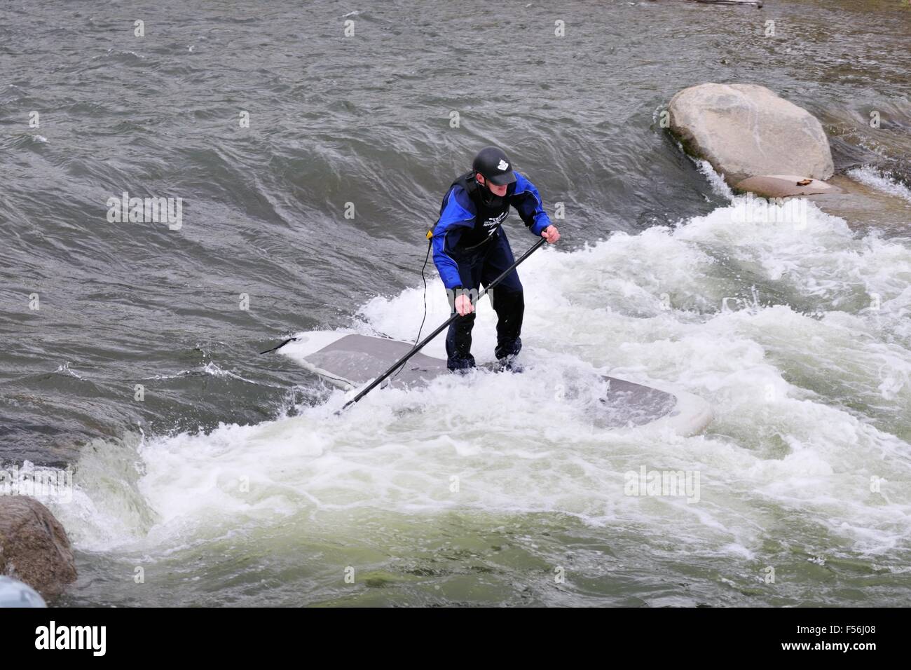 A  paddleboarder maneuvers his board through white water during the 2010 Reno River Festival Stock Photo