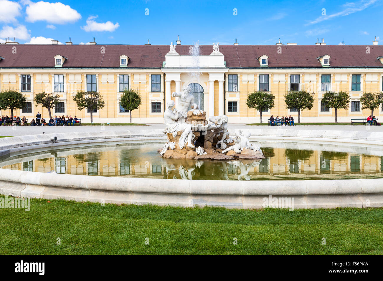 VIENNA, AUSTRIA - SEPTEMBER 29, 2015: tourists on benches near fountain in Schloss Schonbrunn palace garden. Schonbrunn Palace i Stock Photo