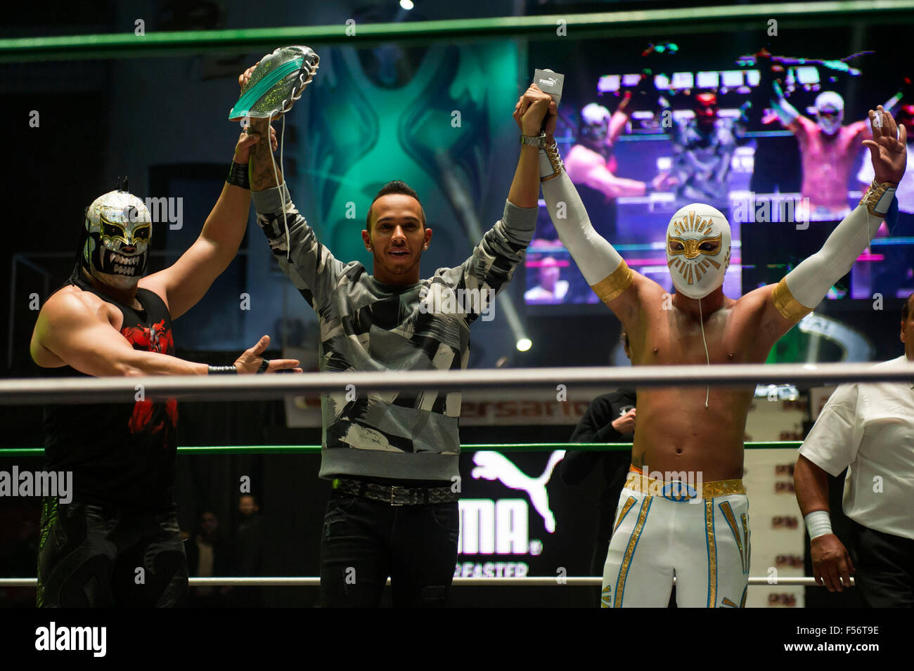 Mexico City, Mexico. 28th Oct, 2015. British driver Lewis Hamilton (C) of Mercedes team, takes part during a wrestling exhibition with 'Mistico' (R) wrestler, during his visit to Arena Mexico, prior to the F1 Mexican Grand Prix, in Mexico City, capital of Mexico, on Oct. 28, 2015. According to local press, Lewis Hamilton visited on Wednesday the Arena Mexico, where he watched a wrestling exhibition and played a match of table football at the ring with Mexican soccer player Oribe Peralta. The F1 Mexican Grand Prix will be held from Oct. 30 to Nov. 1, in Mexico City. Credit:  Xinhua/Alamy Live N Stock Photo