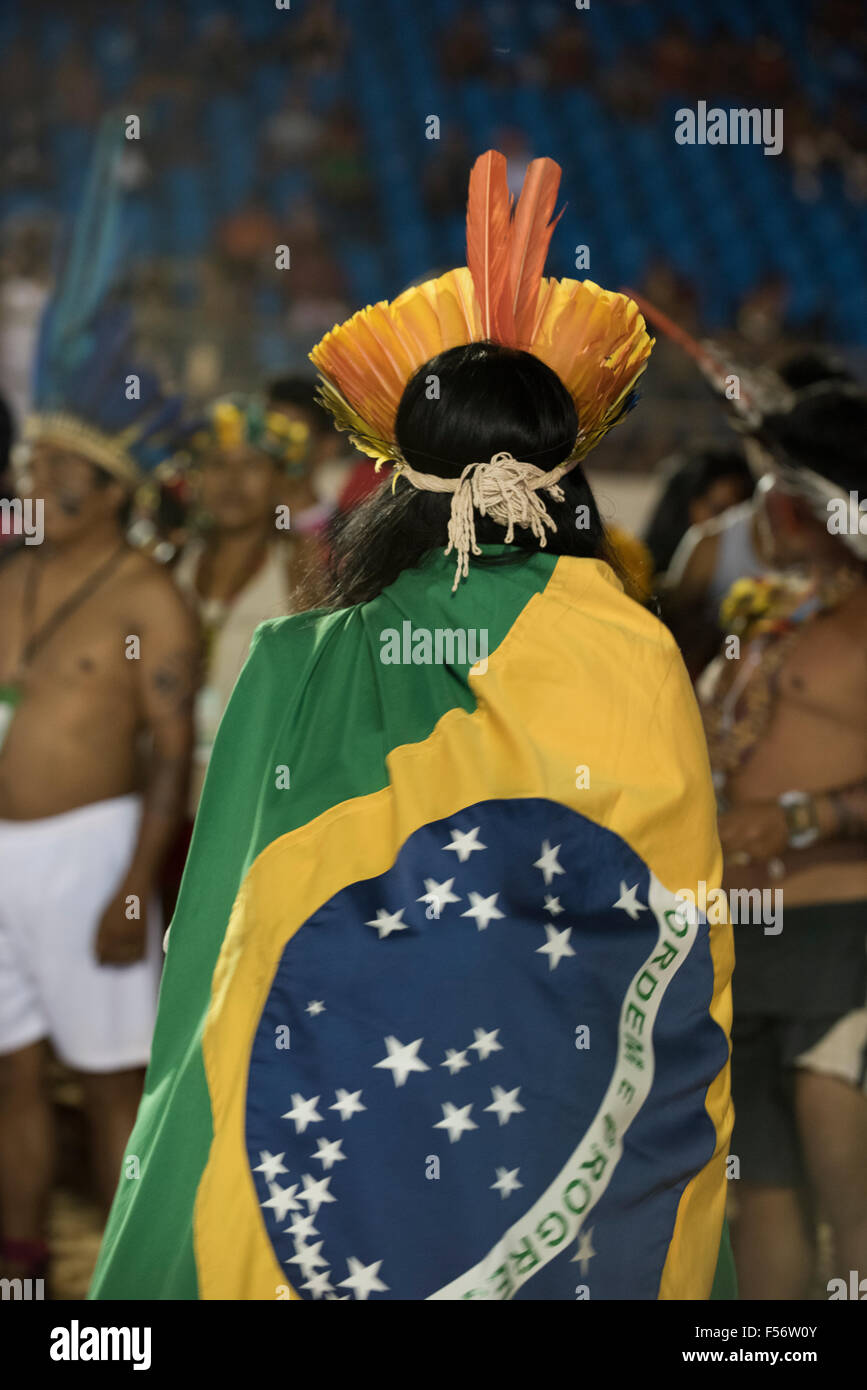 Palmas, Brtazil. 28th Oct, 2015. An indigenous protestor wears the Brazilian flag wrapped around him to demonstrate that he is as much a citizen of Brazil and non-indigenous people during a protest against PEC 215, a proposal to amend the Brazilian constitution to water down indigenous rights at the International Indigenous Games, in the city of Palmas, Tocantins State, Brazil. Credit:  Sue Cunningham Photographic/Alamy Live News Stock Photo