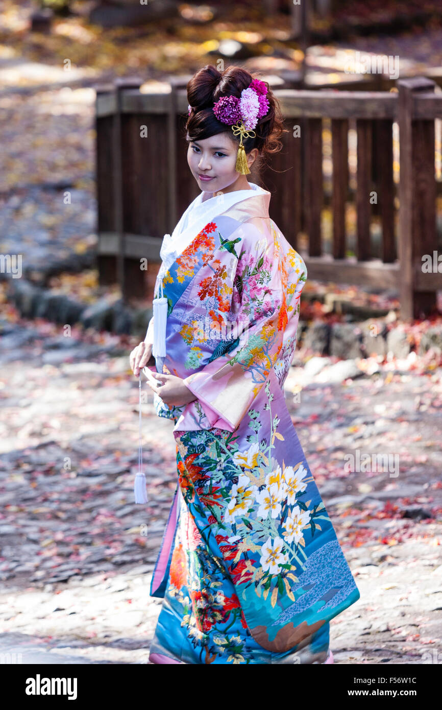 Japan. Japanese women in bridal kimono prosing outside on leave covered  pathway during the autumn. Side view, turned to face. No eye-contact Stock  Photo - Alamy