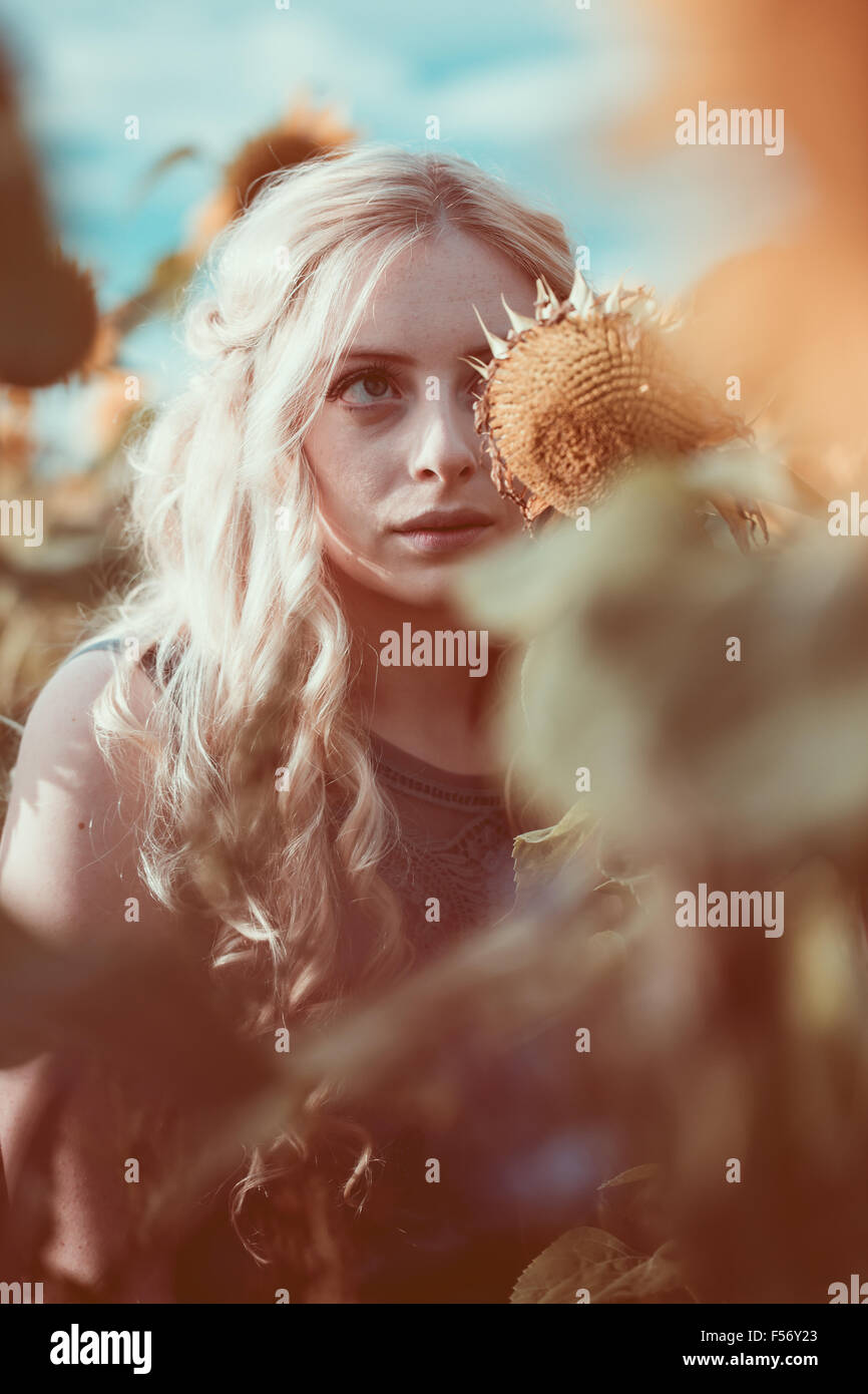 Beautiful young woman in a sunflower field at golden hour Stock Photo ...