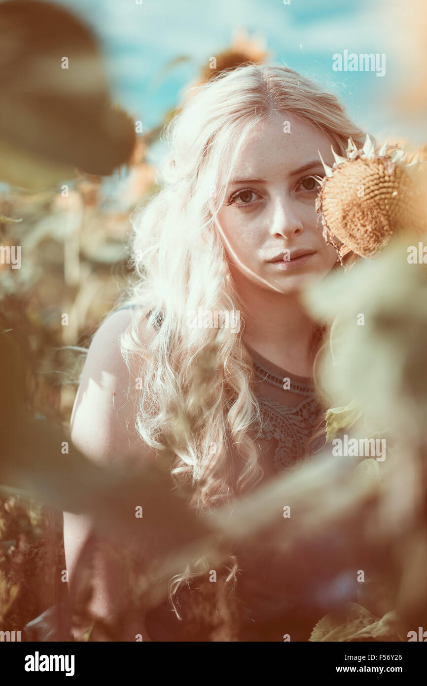 Beautiful young woman in a sunflower field at golden hour Stock Photo ...