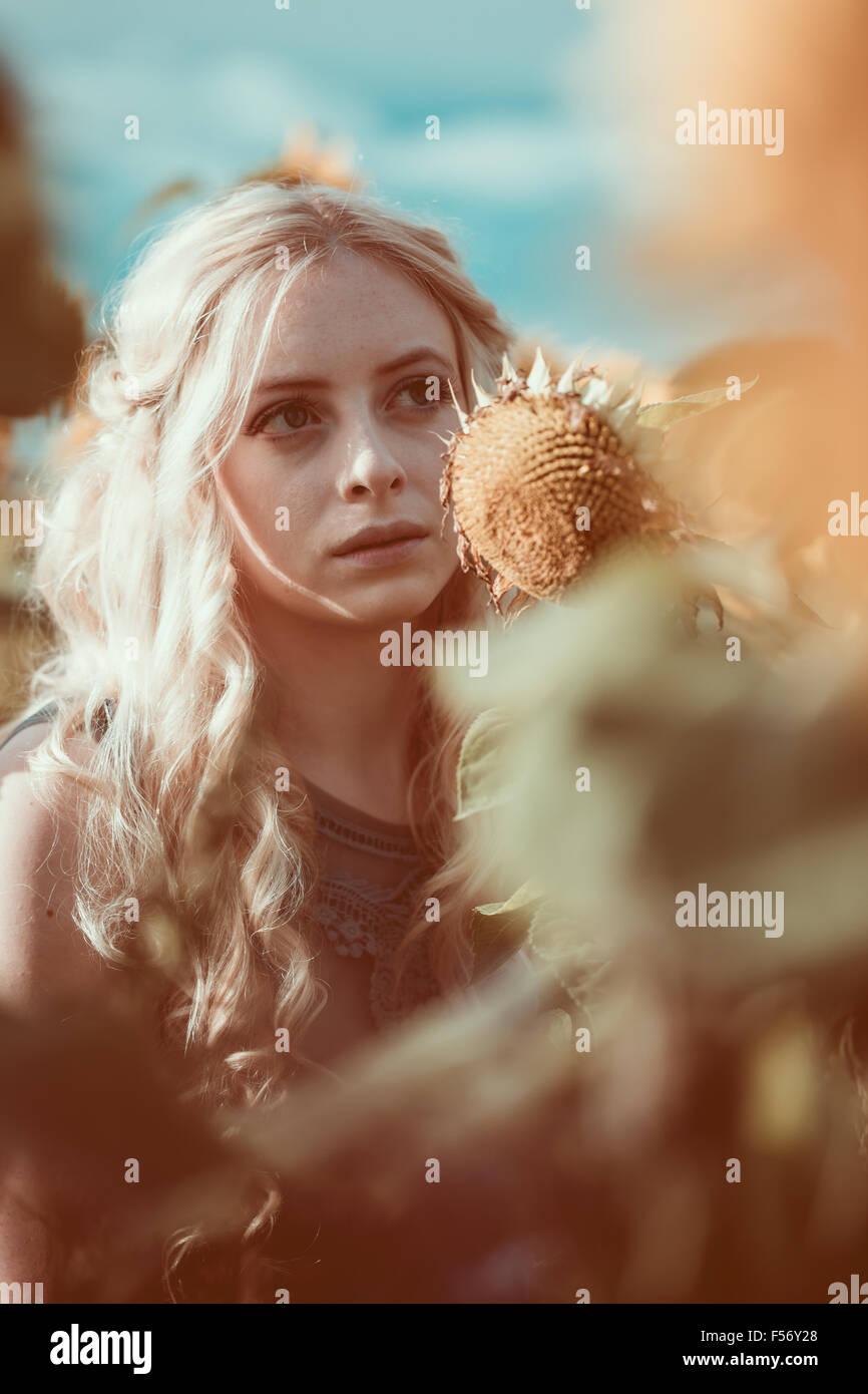 Beautiful young woman in a sunflower field at golden hour Stock Photo ...