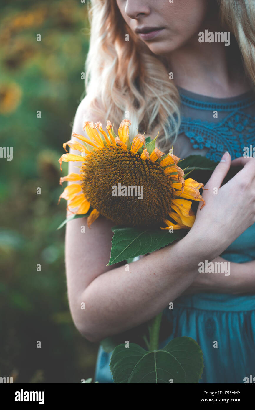 Beautiful young woman in a sunflower field at golden hour Stock Photo ...