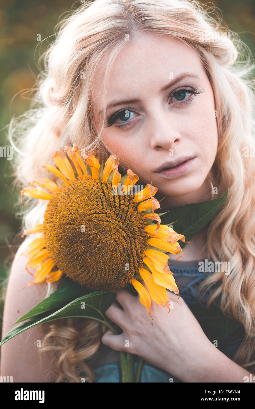 Beautiful young woman in a sunflower field at golden hour Stock Photo ...