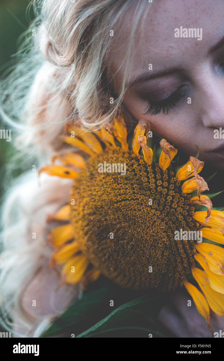 Beautiful young woman in a sunflower field at golden hour Stock Photo ...