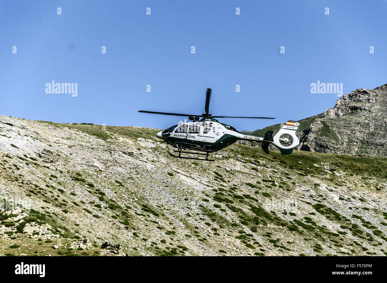 Chopper of Guardia civil patrulling over the mountain in Spain Stock Photo