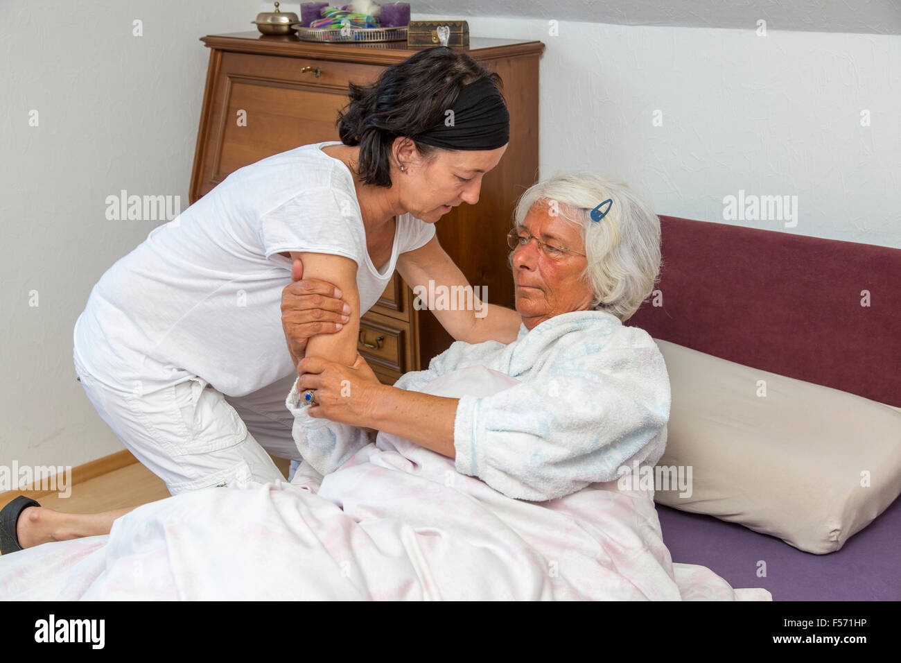 Elderly care at home, Nurse cares for an elderly woman, helping getting