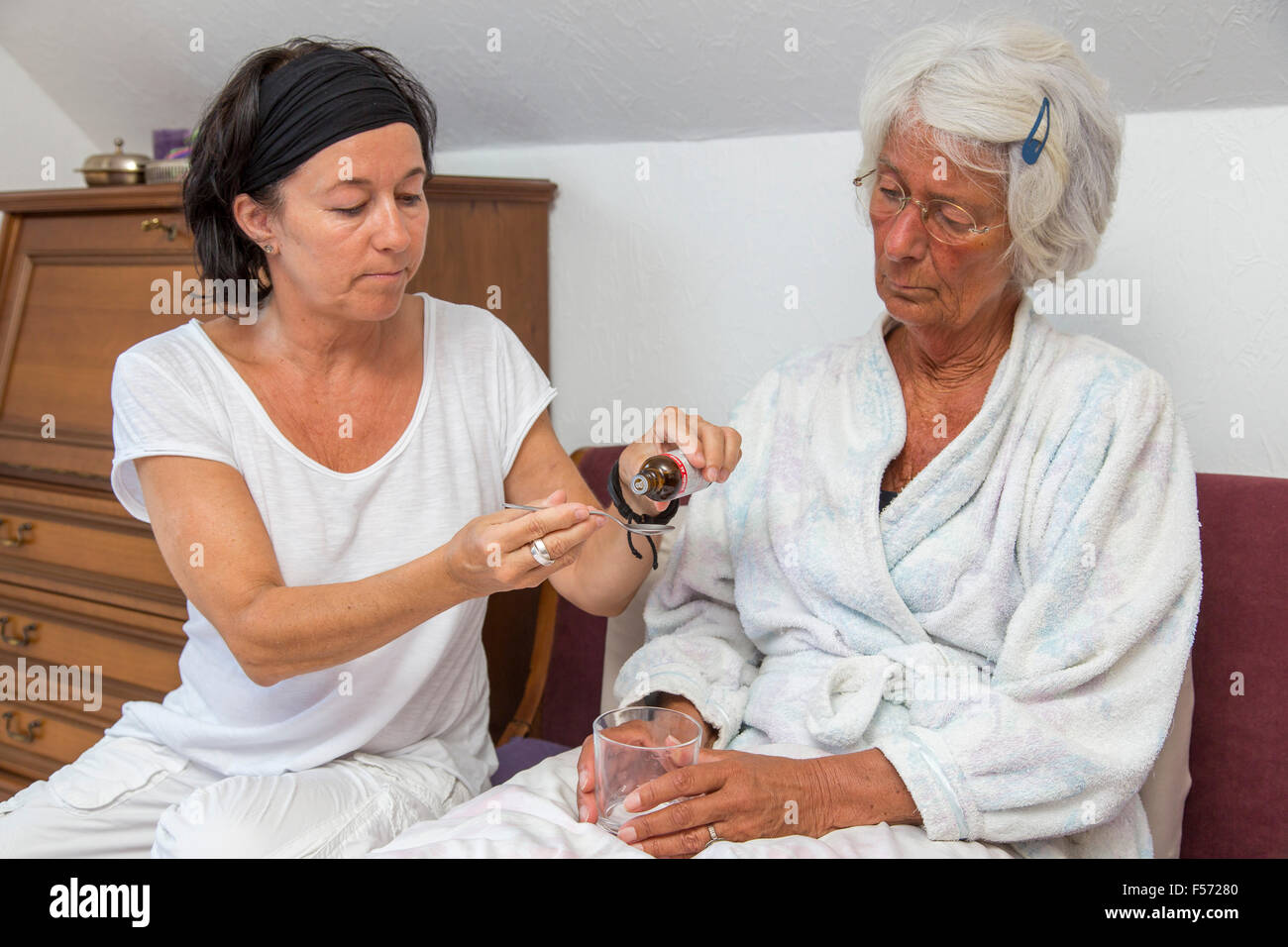 Elderly care at home, Nurse cares for an elderly woman, helping with medicaments, medicine, pills Stock Photo