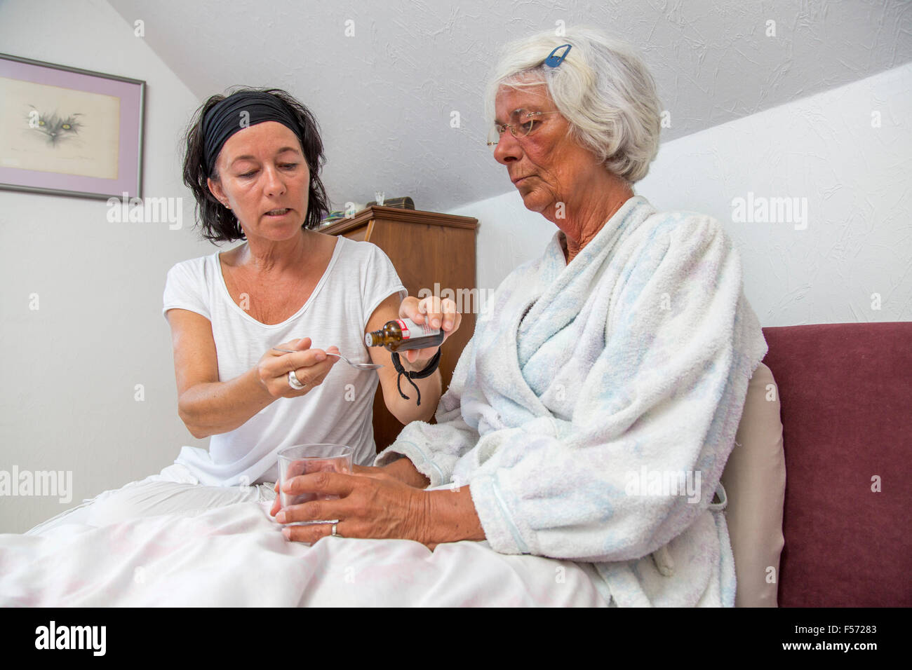 Elderly care at home, Nurse cares for an elderly woman, helping with medicaments, medicine, pills Stock Photo