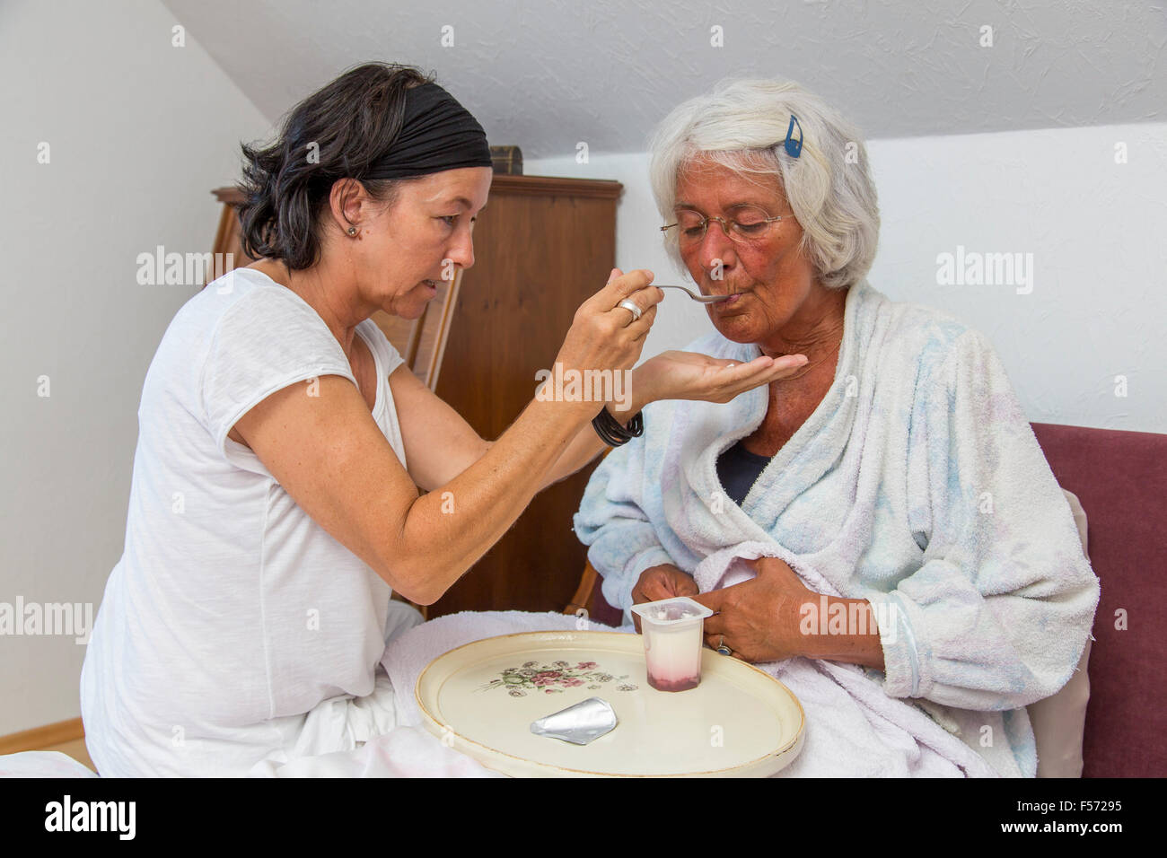 Elderly care at home, Nurse cares for an elderly woman, help with eating, feeding, Stock Photo