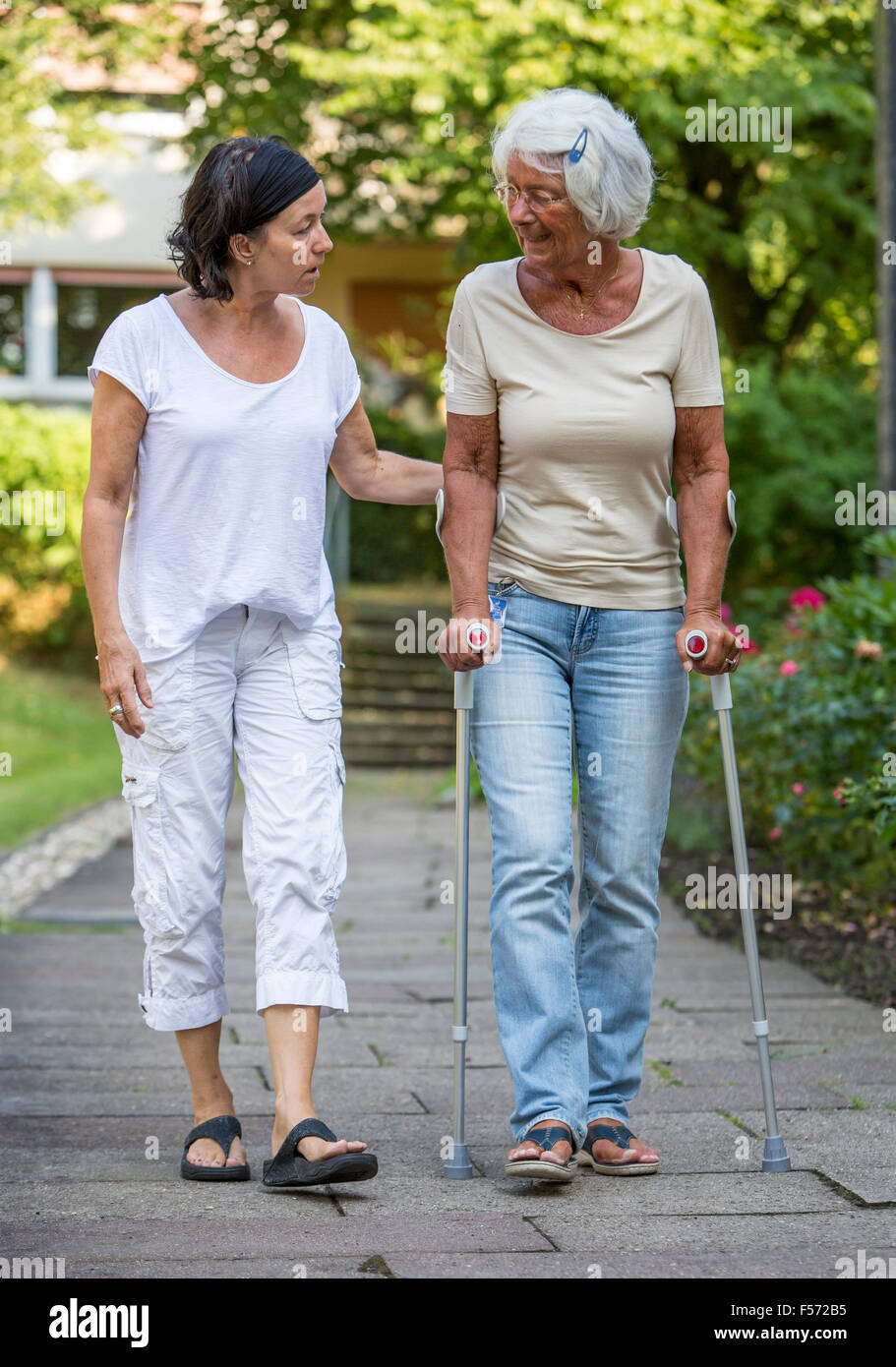 Elderly care at home, Nurse cares for an elderly woman, walking with walking aids, Stock Photo