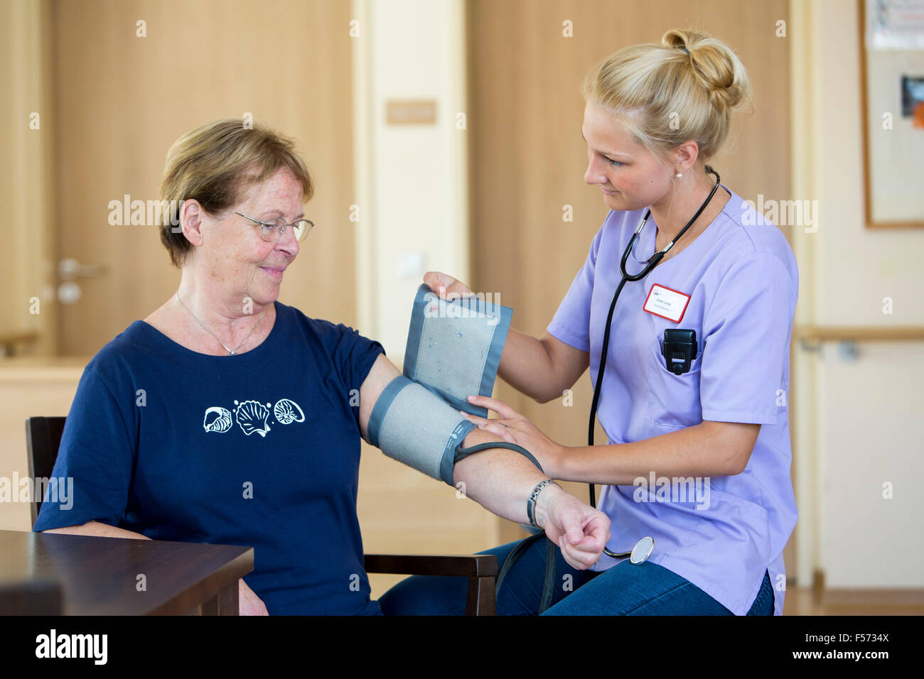 Elderly care in a nursing home, nurse, measuring blood pressure, Stock Photo