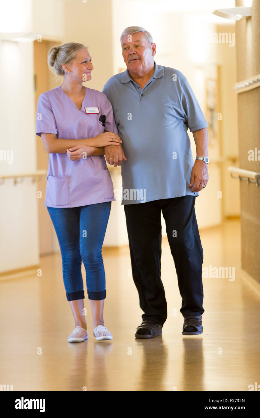 Elderly care in a nursing home, nurse helps an elderly man walking ...
