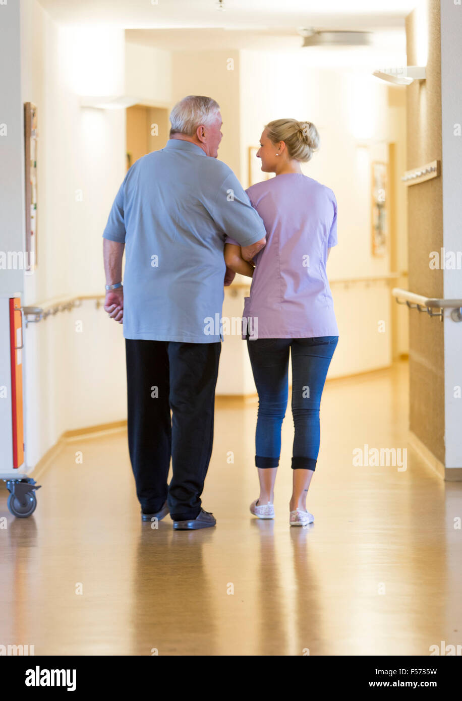 Elderly care in a nursing home, nurse helps an elderly man  walking Stock Photo