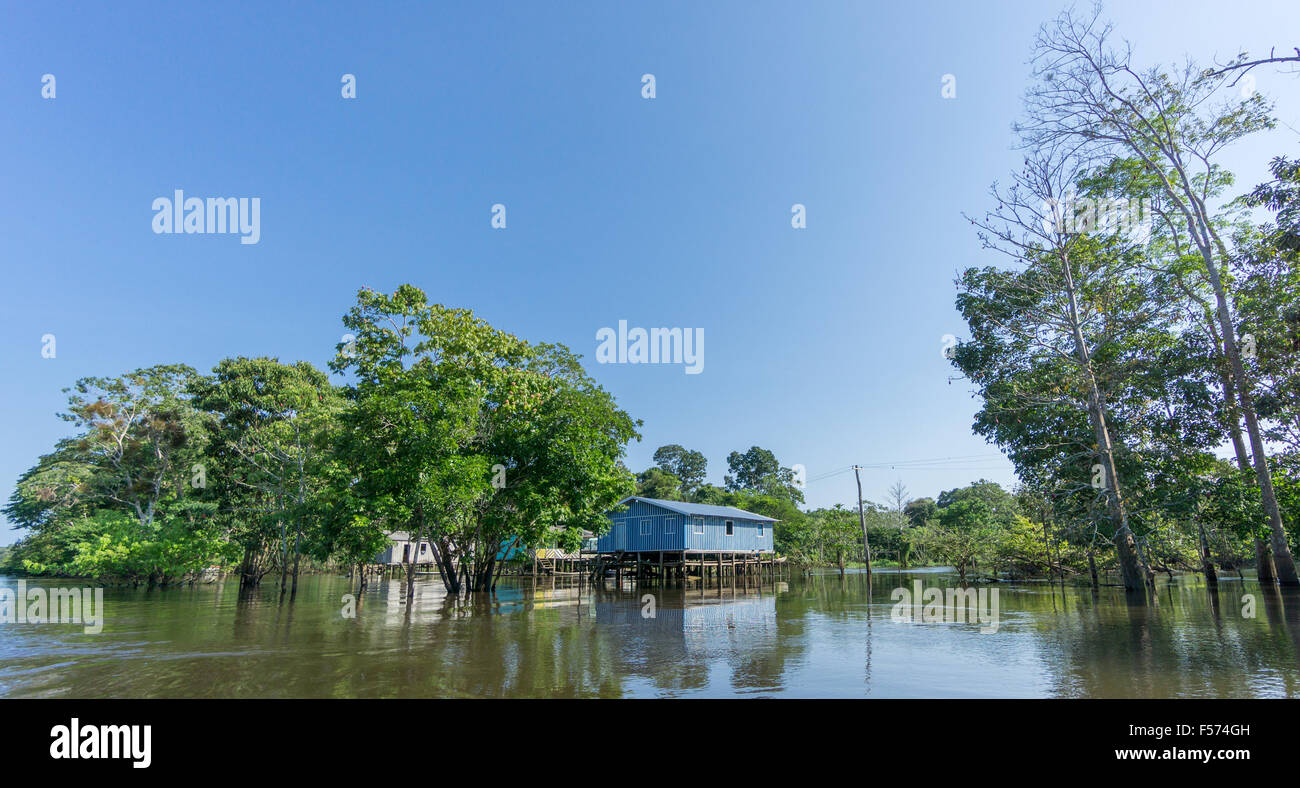 Woode houses built on high stilts over water, Amazon rainforest Stock