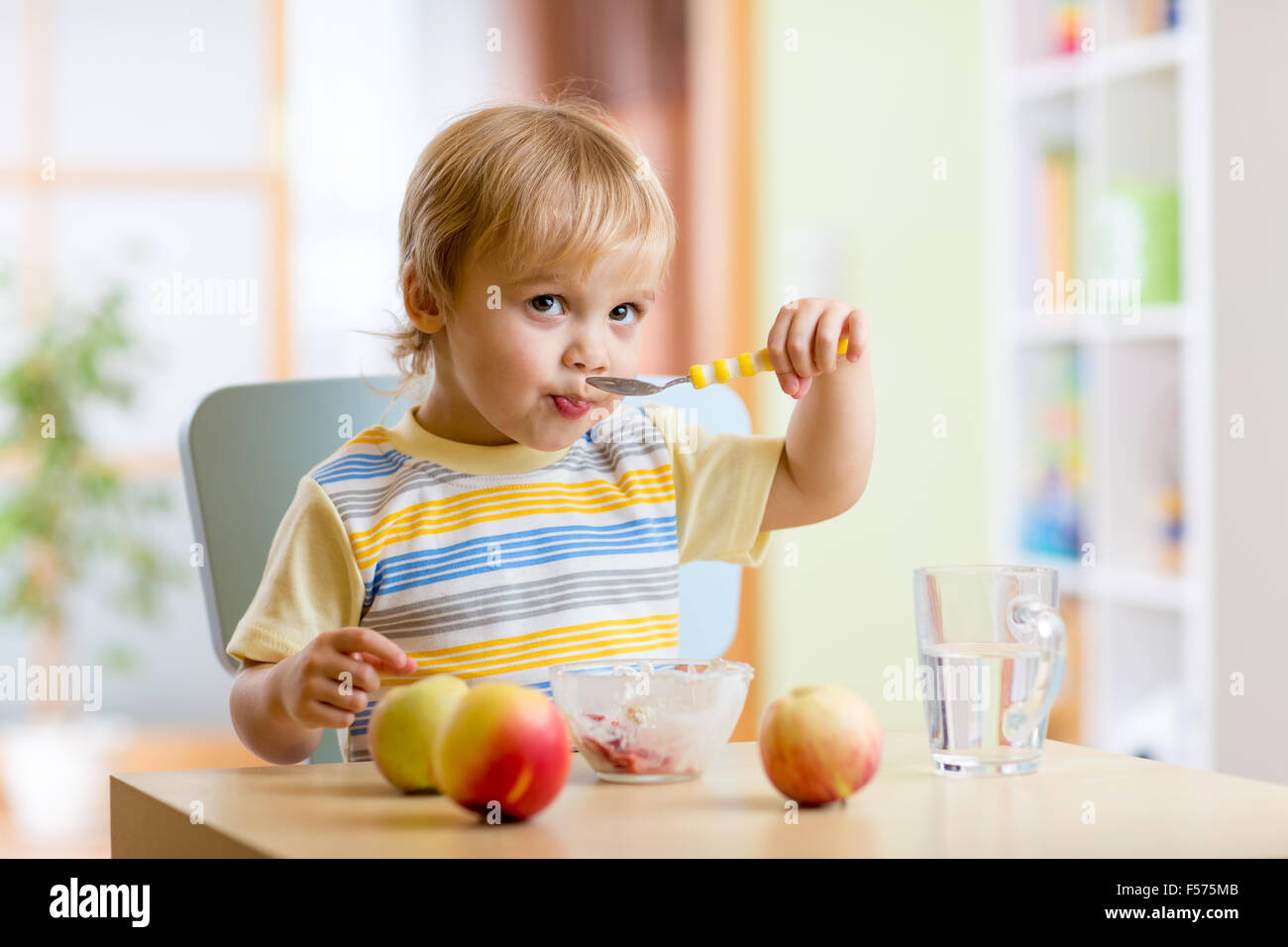 child eating healthy food with a spoon at home Stock Photo