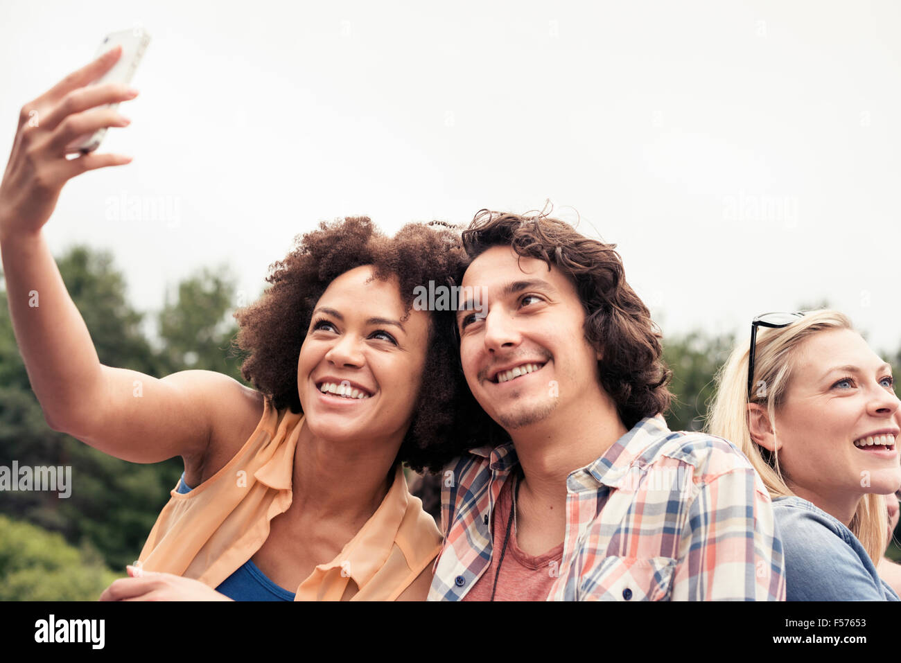 A young couple, a man and woman taking a selfie with a smart phone. Stock Photo