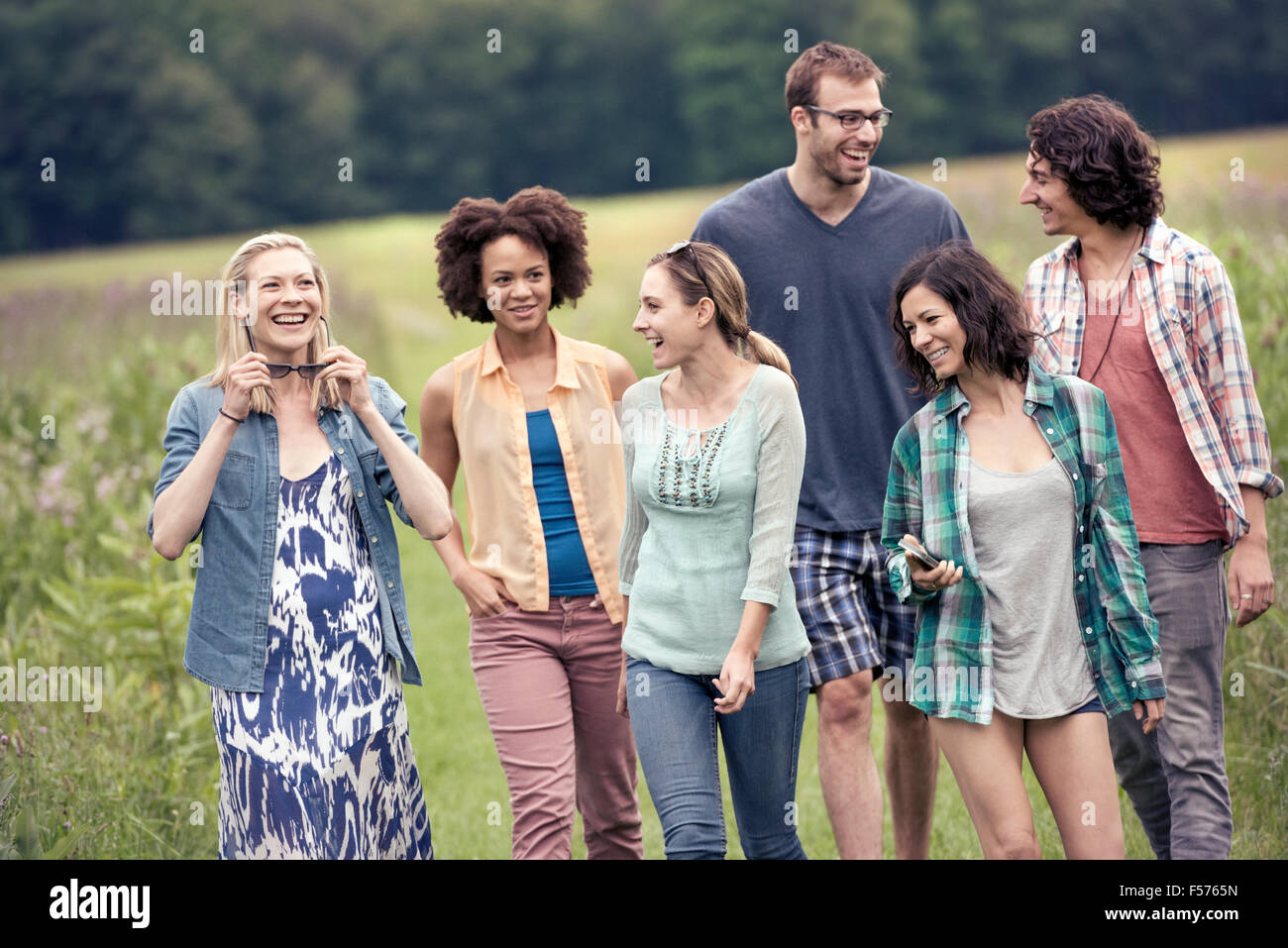 A group of people, a man and five women, walking through the countryside. Stock Photo