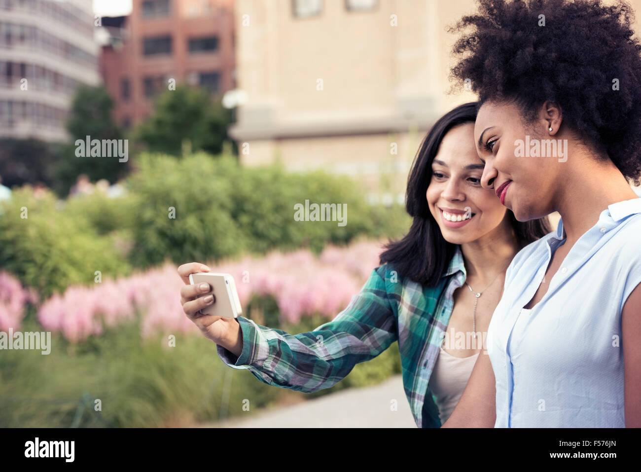 Two women posing and taking a selfie in the city Stock Photo