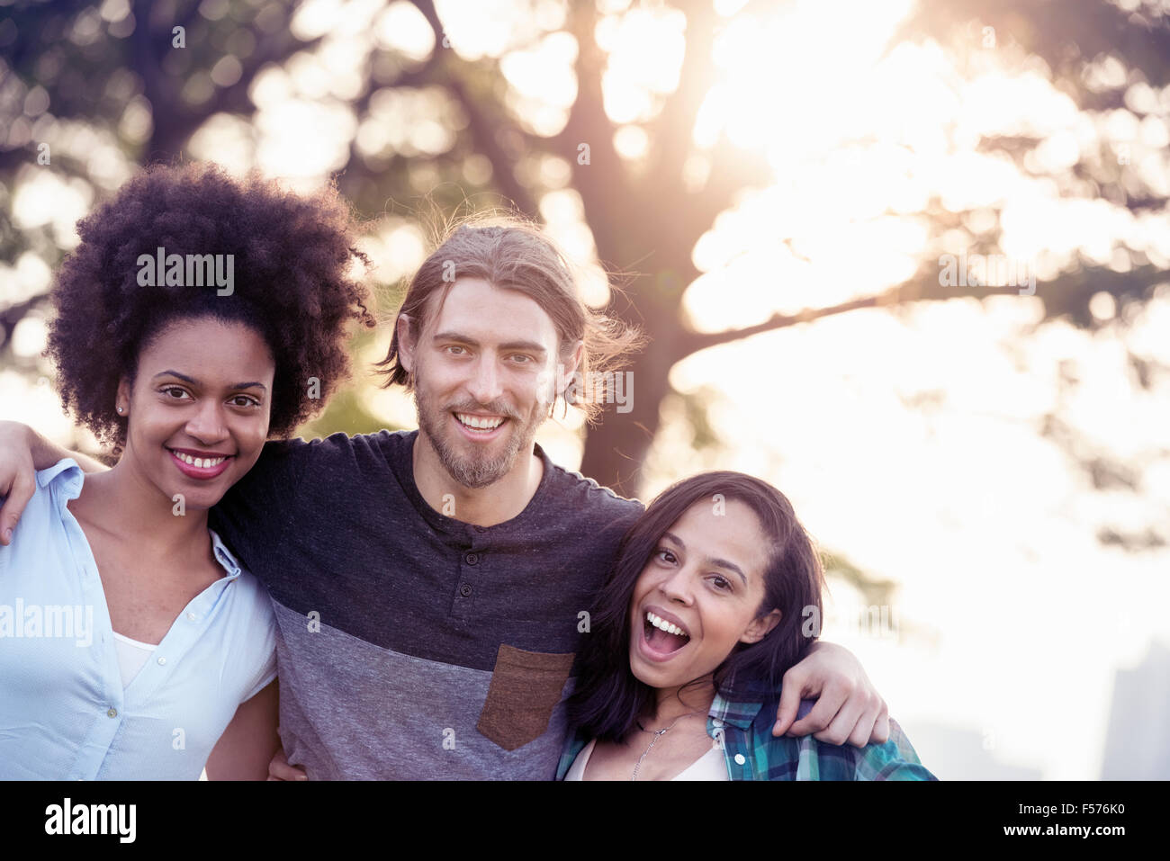 Three people, a man and two women side by side smiling Stock Photo
