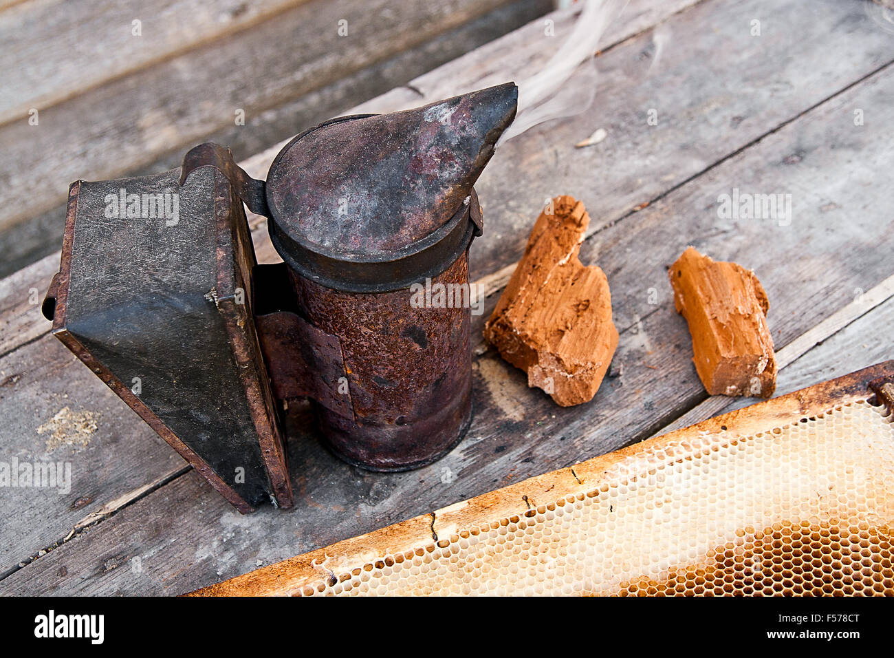 Old smoker at beehive on the wooden table. Stock Photo