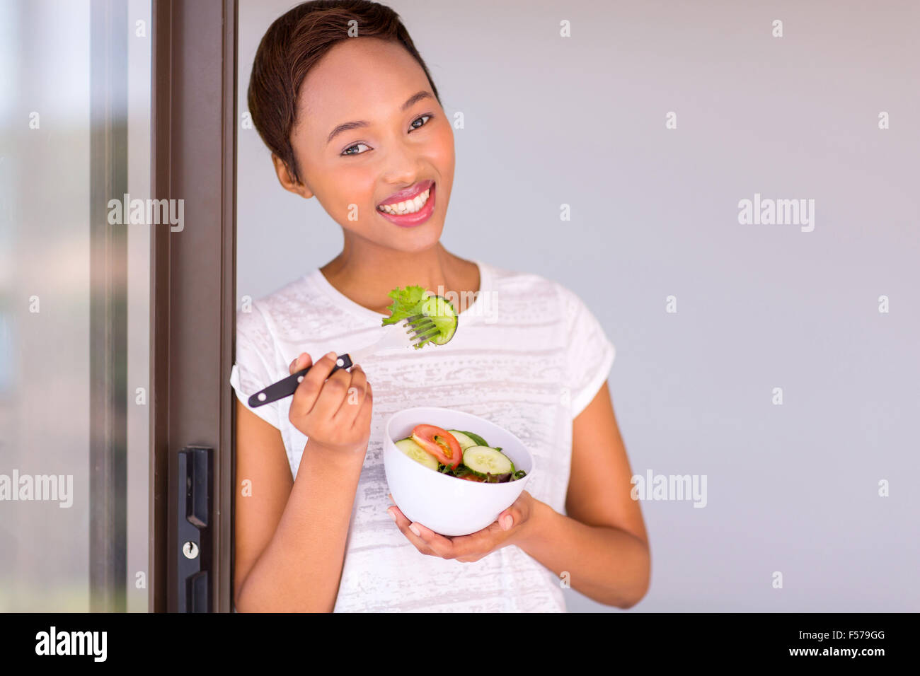 attractive black woman eating green salad Stock Photo