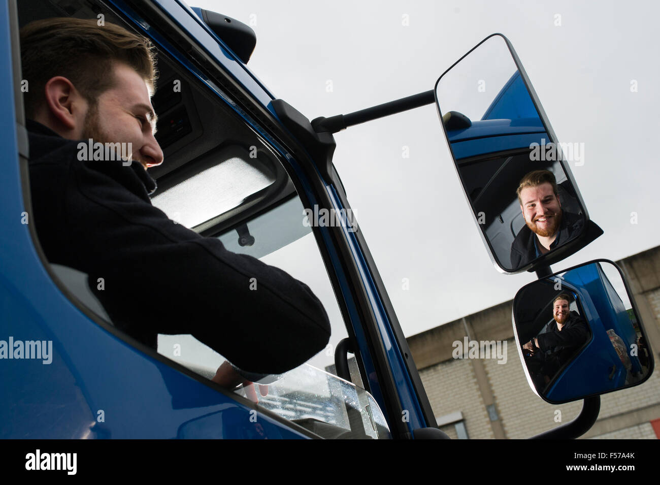 young lorry driver looking in the mirror (MR) Stock Photo