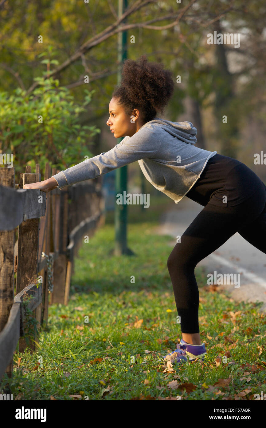 Side view of young active woman stretching her muscles outdoors Stock ...